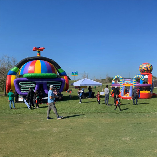 Kids and families playing on inflatable obstacle courses and bounce houses at a public carnival in Kissimmee Florida